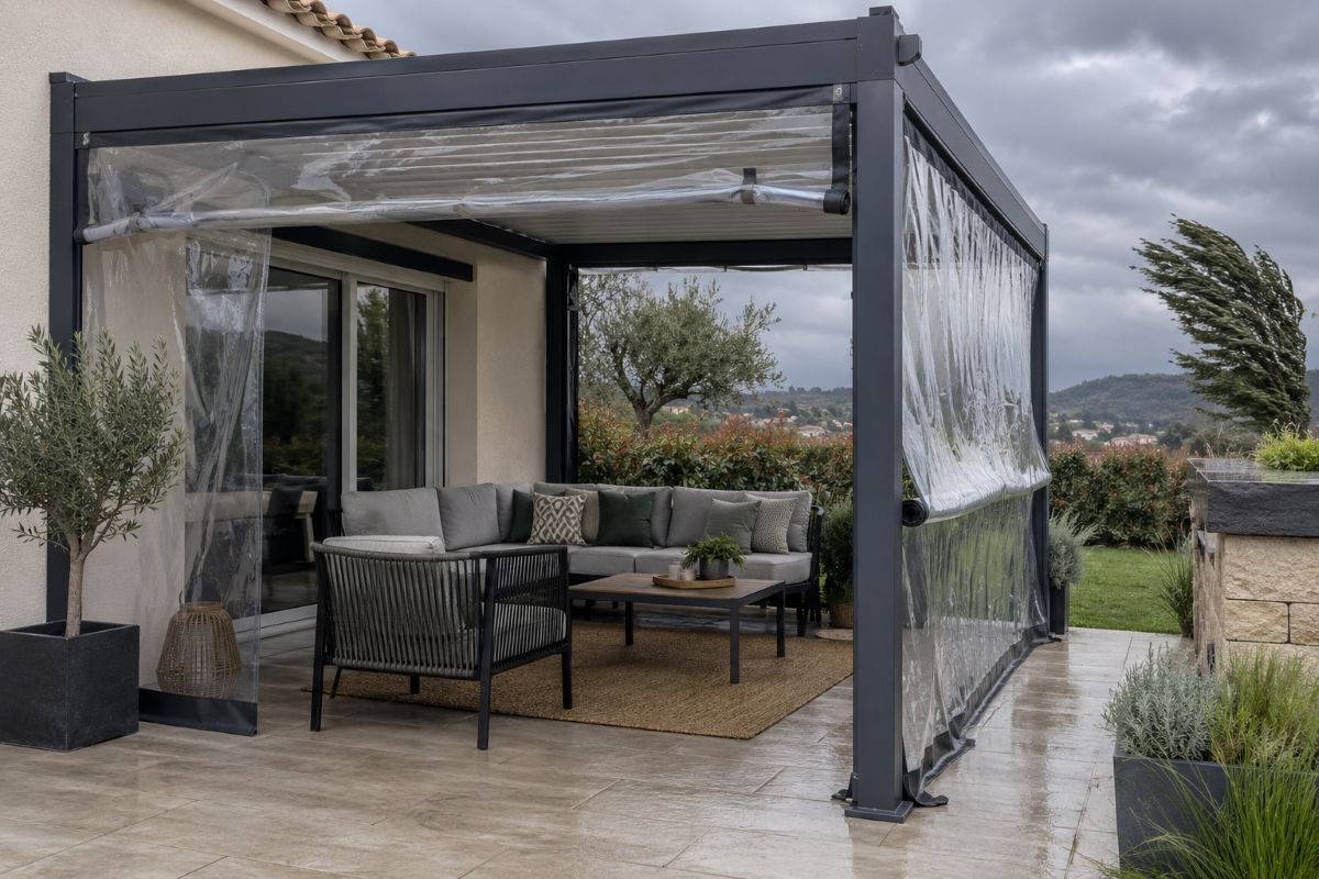 Pergola de terrasse fermée sur les côtés par des bâches transparentes enroulables