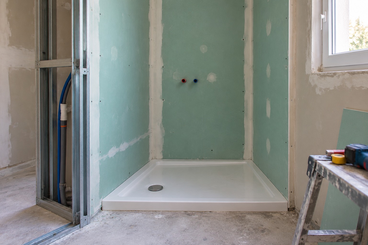 Cloison en plaques de plâtre hydrofuges vertes vissées sur ossature métallique dans une salle de bain en travaux
